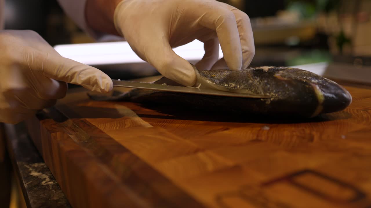 Chef Skilfully Slicing Fish On Cutting Board