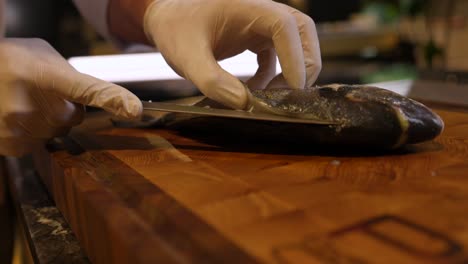 chef skilfully slicing fish on cutting board