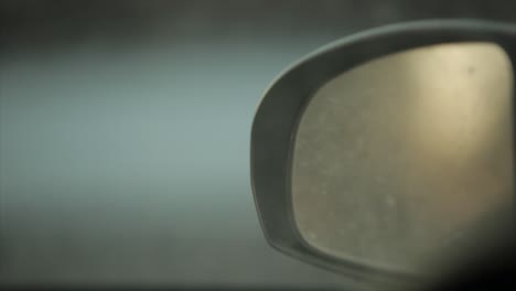 un primer plano de un espejo de coche al atardecer