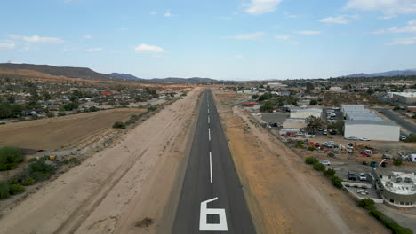 aerial drone shot traveling down the runway at a small general aviation airport