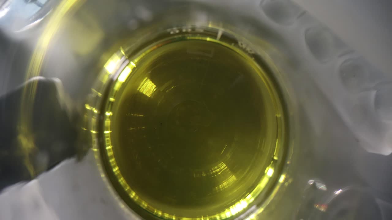 Provetta da laboratorio con liquido oleoso giallo