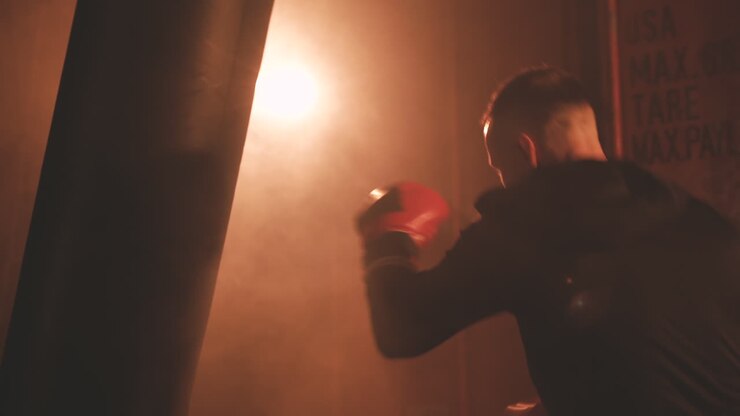 Deportista calienta golpeando el saco de boxeo
