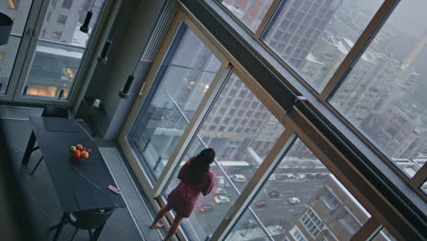 relaxed woman looking panoramic window at hotel high angle view. model thinking