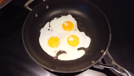 freír tres huevos fritos en una sartén