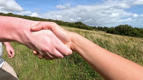 two people shaking hands in a field