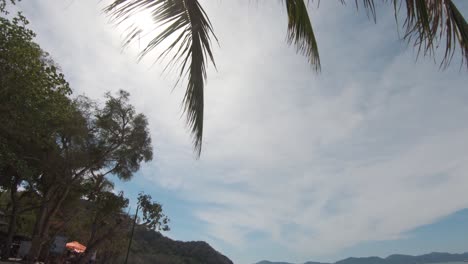 Blick-Von-Der-Sonne,-Die-Durch-Palmen-Scheint,-Auf-Den-Idyllischen-Exotischen-Strand-In-Koh-Hey,-Thailand