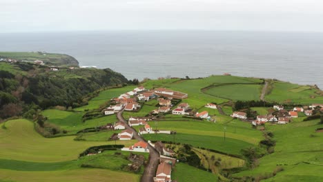 Imágenes-De-Drones-De-Una-Exuberante-Y-Verde-Campiña-Volcánica-Con-Casas-Y-Carreteras-Cerca-De-Acantilados-Oceánicos-En-Una-Tarde-Brumosa-En-Las-Azores,-Isla-De-Sao-Miguel