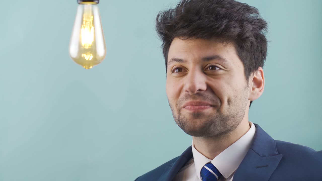 un hombre de negocios reflexivo tiene una nueva idea y la lámpara de la idea se enciende.