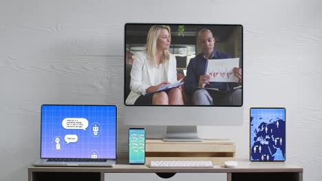 Diverse-business-people-on-computer-video-call-with-digital-screens-in-office