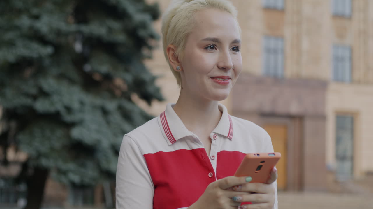 молодая женщина использует смартфон на открытом воздухе