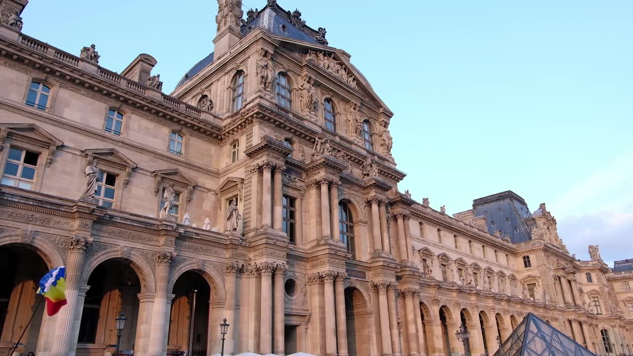 Paris, France - April 21, 2021: The Romanian flag waving in front of the Louvre Museum in daylight