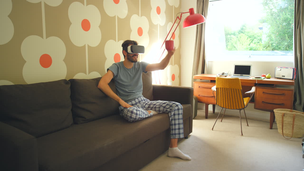 hombre con auriculares vr y bebiendo café en un sofá