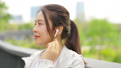 4k asian woman listening to music while jogging at public park in the morning.