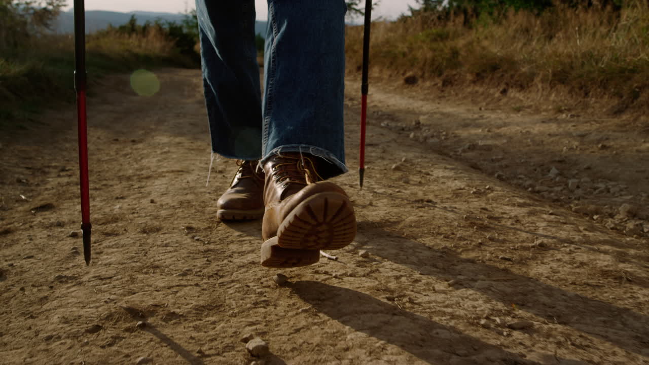 hombre con botas de senderismo caminando por un camino de tierra