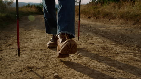 man in hiking boots walking on dirt road