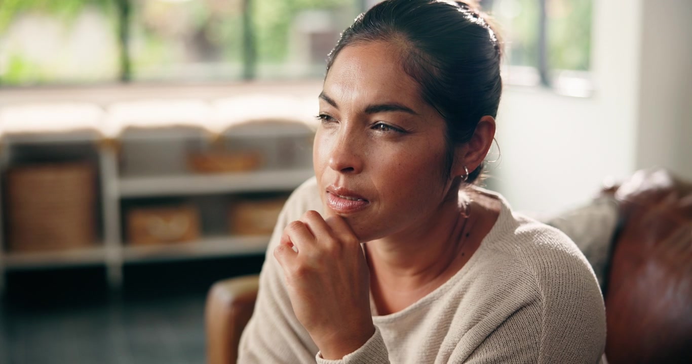 Thoughtful Woman Sitting at Home Contemplating