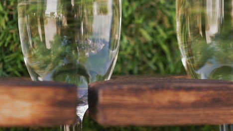 champán de lujo en copas de vino en un estante por césped artificial