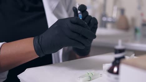 médico profesional con guantes y máscara con jeringa médica en las manos, preparándose para la inyección