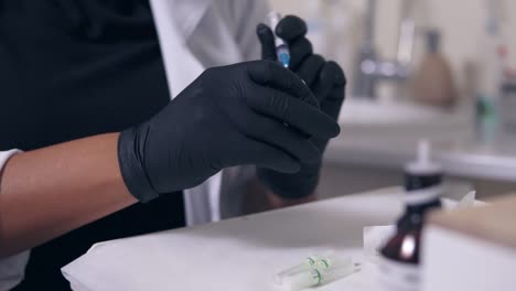 professional doctor in gloves and mask with medical syringe in hands, getting ready for injection