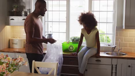 Hija-Afroamericana-Y-Su-Padre-Clasificando-El-Reciclaje-Y-Chocando-Los-Cinco-En-La-Cocina