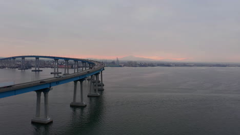 Puente-Curvo-Coronado-Cruzando-La-Bahía-De-San-Diego-Con-Vistas-Al-Horizonte-De-California-Al-Amanecer-En-Estados-Unidos