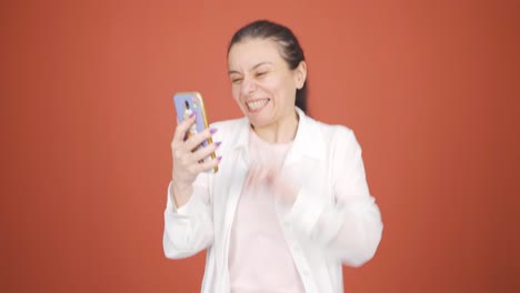 the woman looking at the phone is happy.