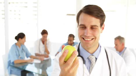 Handsome-doctor-holding-an-apple