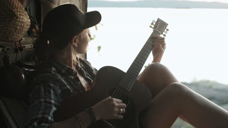 une femme jouant de la guitare dans une camionnette