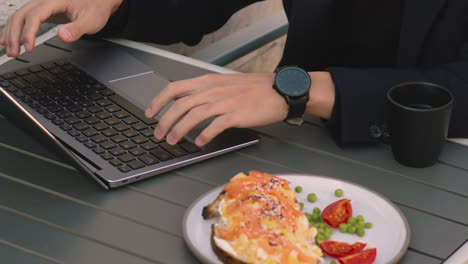 cierre de un hombre de negocios irreconocible que cierra su computadora portátil y está listo para almorzar en una cafetería