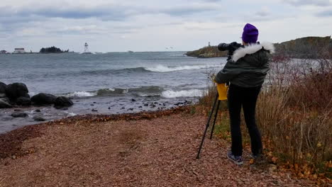 photographer taking photos of waves on lake superior, grand marais, minnesota