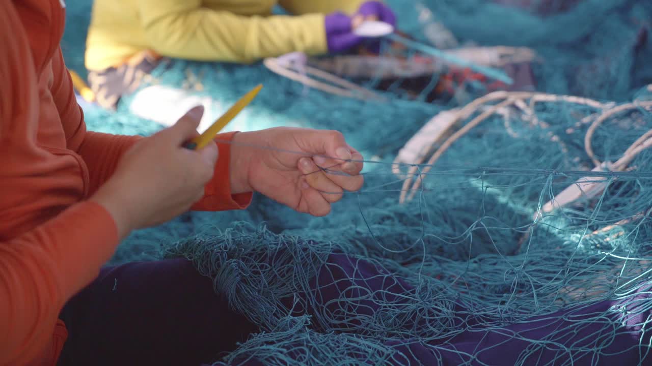 Lavorazione a maglia di una rete da pesca - un lavoro tradizionale vietnamita, città di Nha Trang, provincia di Khanh Hoa, Vietnam centrale