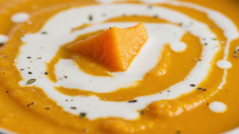 creamy pumpkin or butternut squash soup with cream swirl and garnish