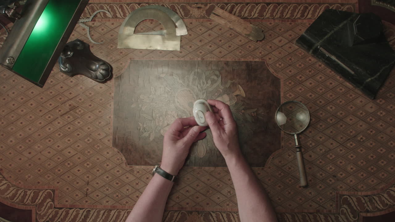 An older man evaluates a small ceramic box