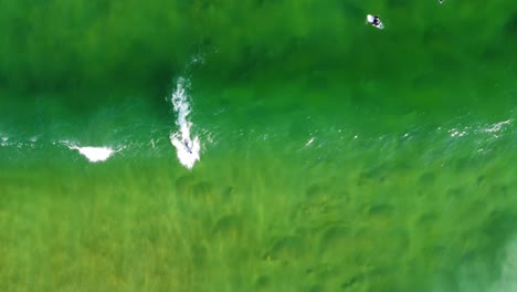 aerial drone footage bird's-eye view of surfer riding wave on crystal clear sandbank avoca central coast nsw australia 4k