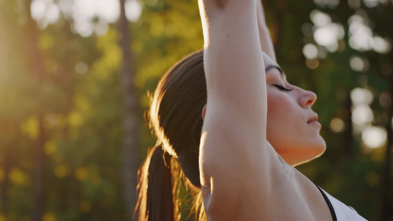 Close-up of a woman in activewear exercising outdoors at golden hour