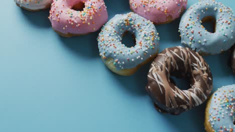 Video-Von-Donuts-Mit-Zuckerguss-Auf-Blauem-Und-Violettem-Hintergrund