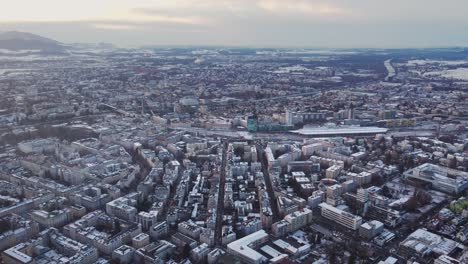 aerial of salzburg cityscape, flying above buildings, snow white city winter