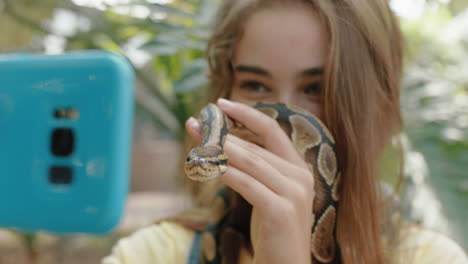 Chica-De-La-Naturaleza-Sosteniendo-Una-Serpiente-Tomando-Una-Foto-Selfie-Usando-Un-Teléfono-Inteligente-Disfrutando-De-Una-Excursión-Al-Zoológico-Compartiendo-Reptiles-Espeluznantes-En-Las-Redes-Sociales-4k