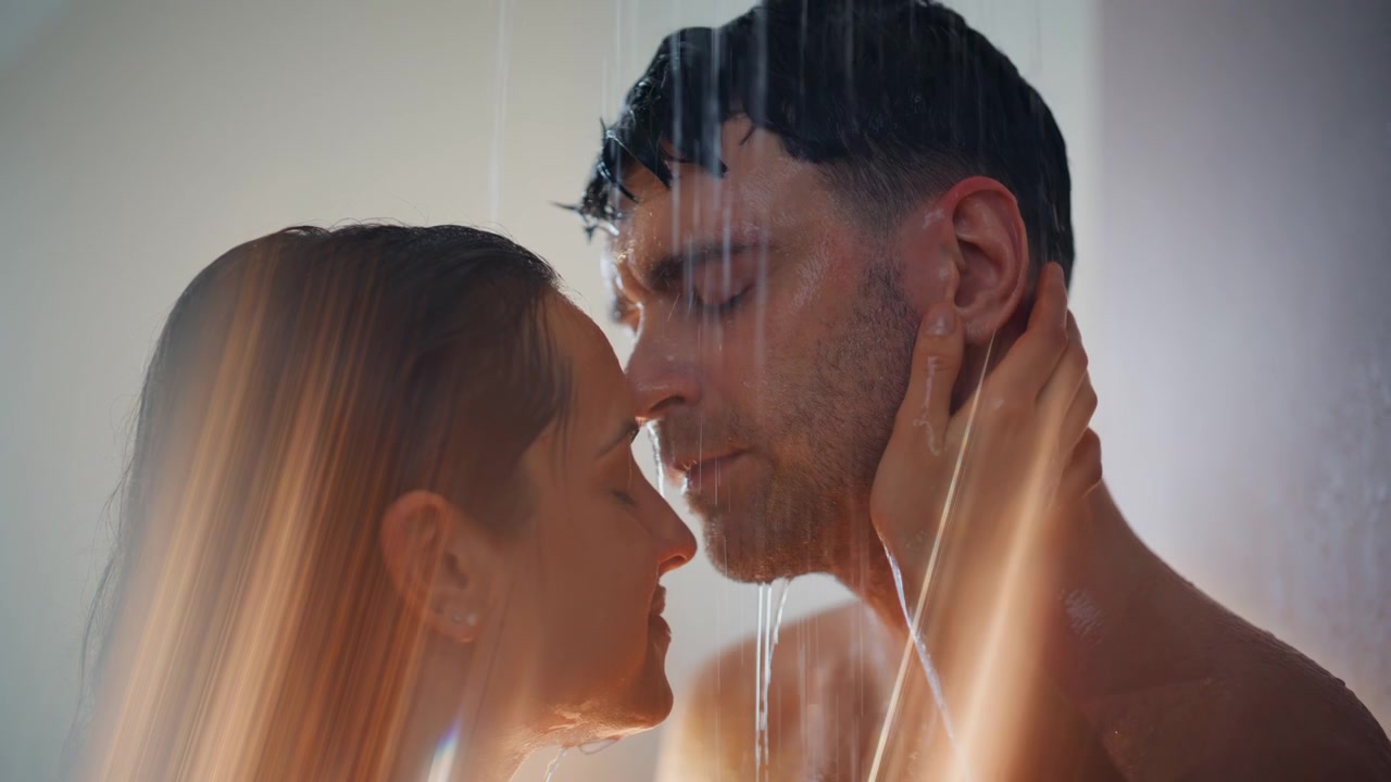 Passionate couple embracing shower water. Close up wet lovers touching tenderly.