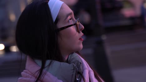 Beautiful-young-woman-looks-around-in-Picadilly-Circus,-London,-UK,-close-up