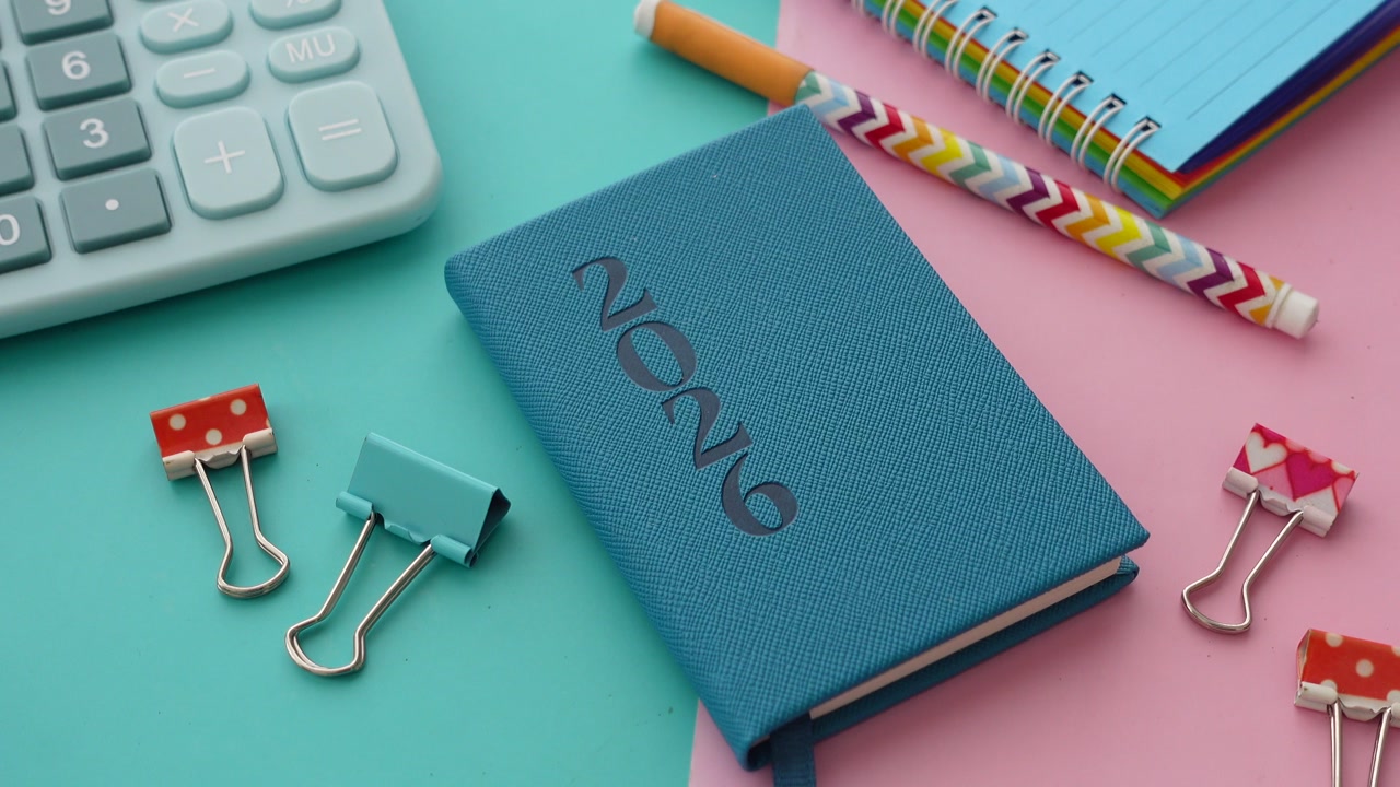 Flat Lay of Colorful Stationery and 2020 Planner on Pink and Blue Background