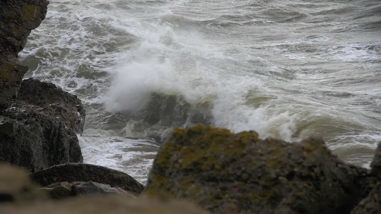 grandes olas golpeando las ruinas del edificio de defensa costera de hormigón abandonado en un clima tormentoso en cámara lenta