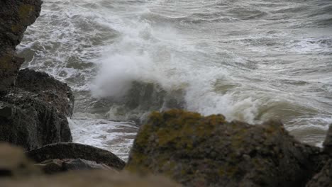 big waves hitting the abandoned concrete coast defense building ruins in stormy weather in slow motion