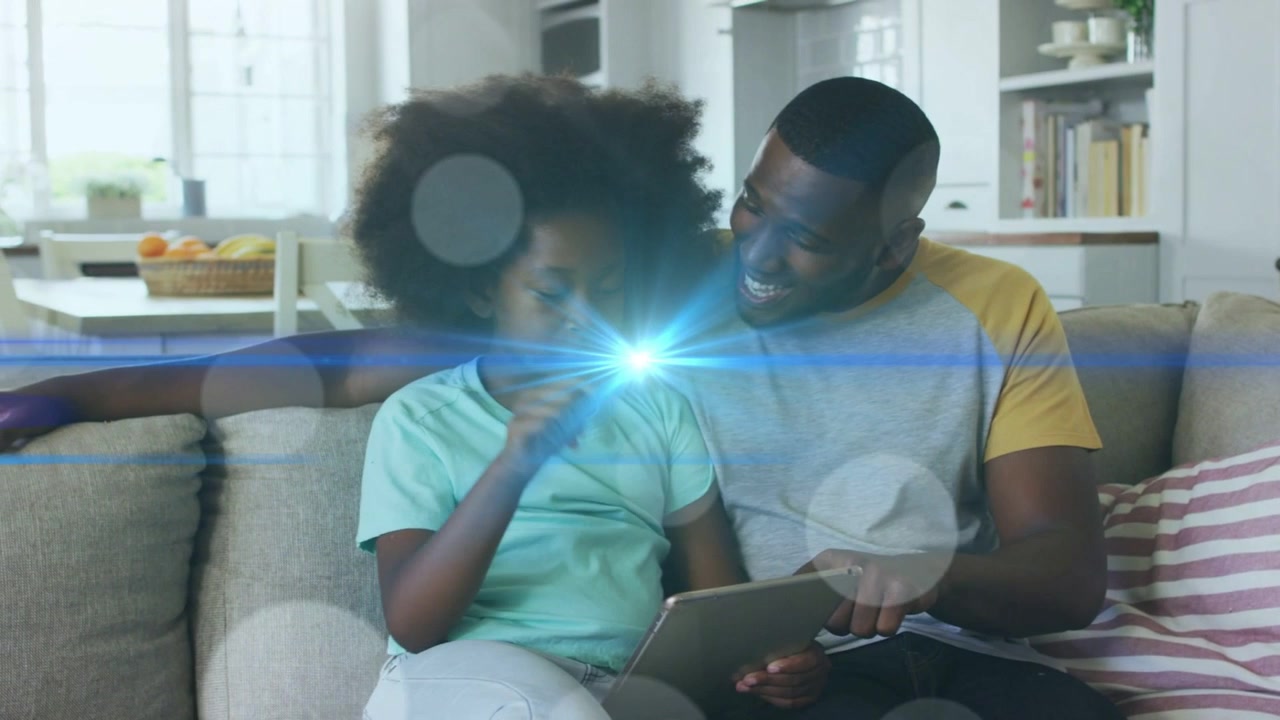 Dad and daughter on sofa tapping tablet, starting blue flare crossing faces and showing learning