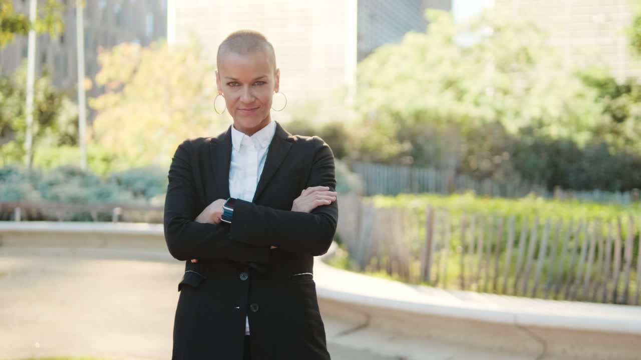 Confident Businesswoman with Shaved Head Standing Outdoors with Arms Crossed