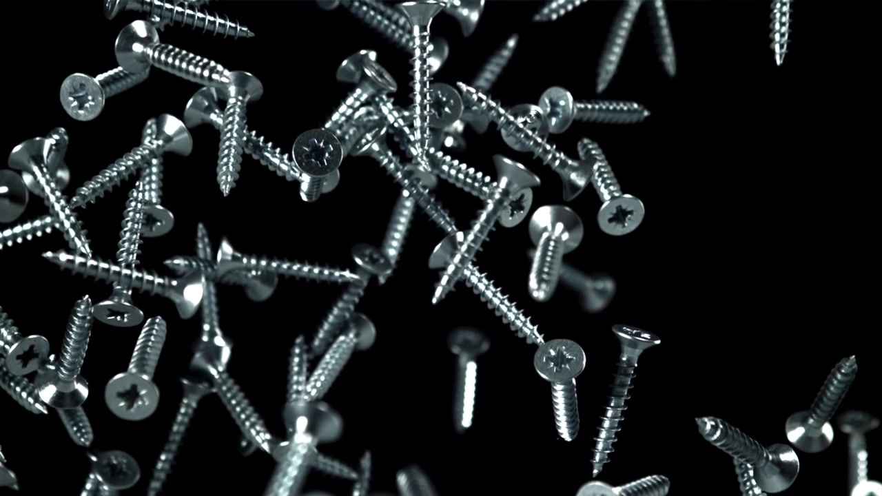 Silver Metal Screws Falling in Slow Motion on Black Background