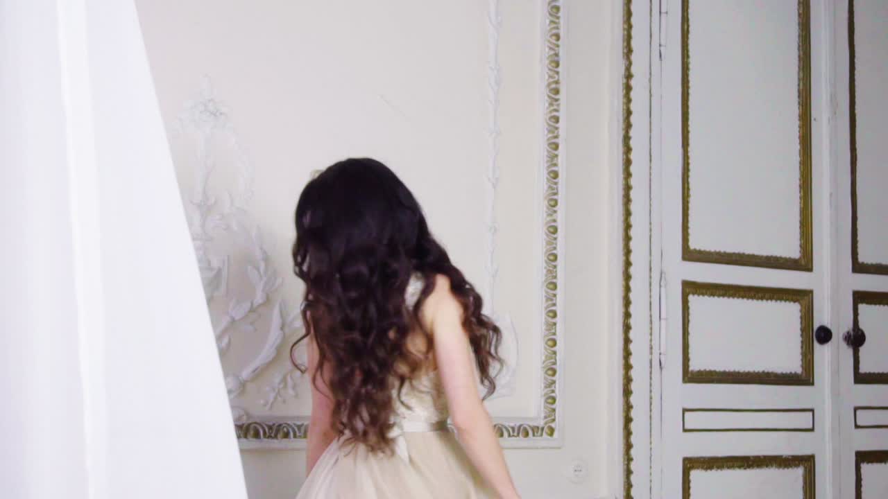 una joven morena baila en un largo vestido de noche