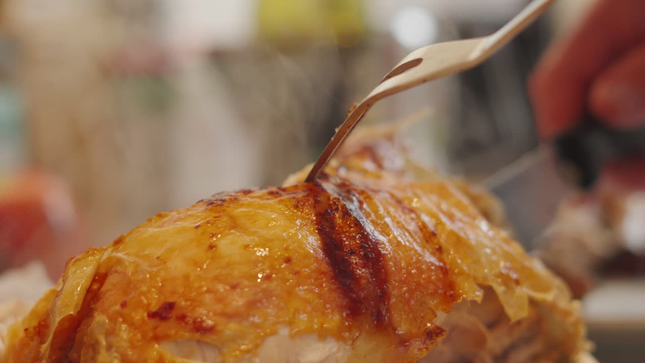 Camera Focus on Long Fork as Chef Carves Chicken Joint with Carving Knife with Hot Steam Rising in Slow Motion. Traditional British Sunday Dinner Food Meat.