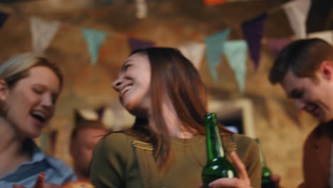 happy millennials dancing party with beer bottles close up. young women laughing