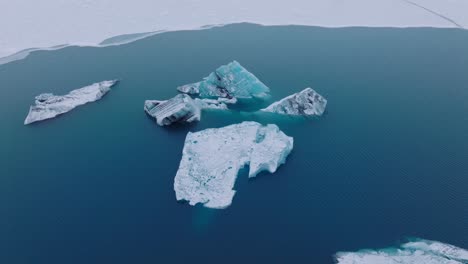 Aerial-view-of-icebergs-in-the-glacial-water-of-Jokulsarlón-lake,-in-Iceland,-during-winter